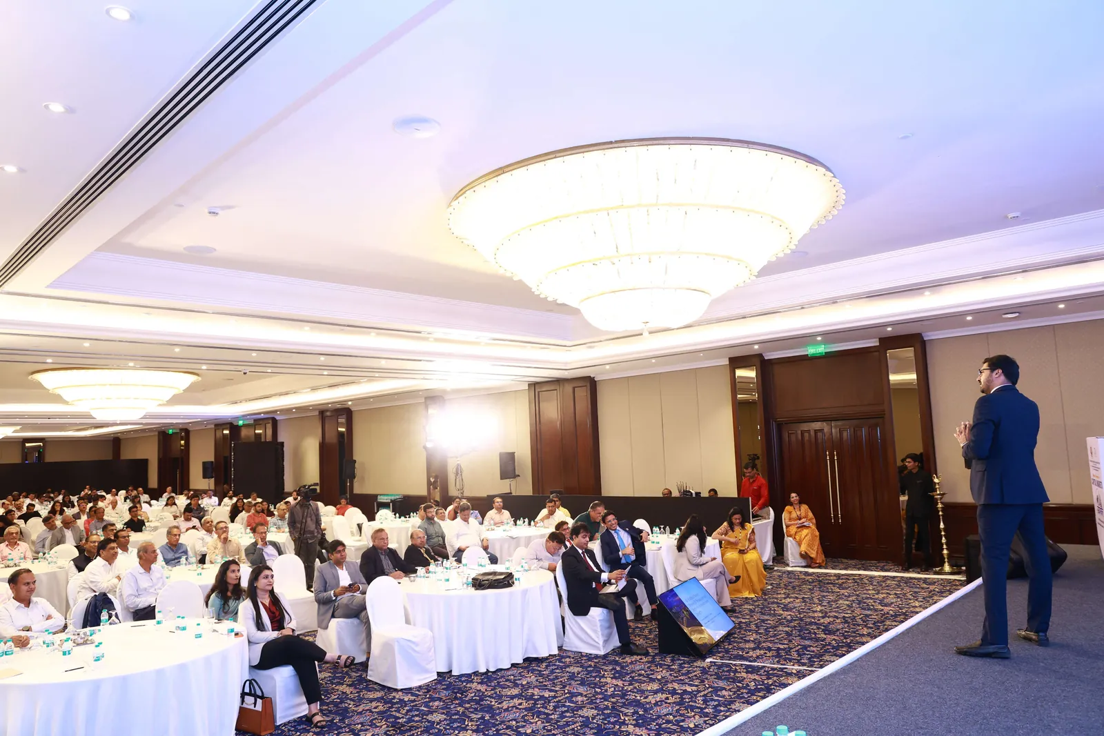 CA Dhaval Kodilkar addressing delegates seated at round tables during the ICAI conference in Mumbai