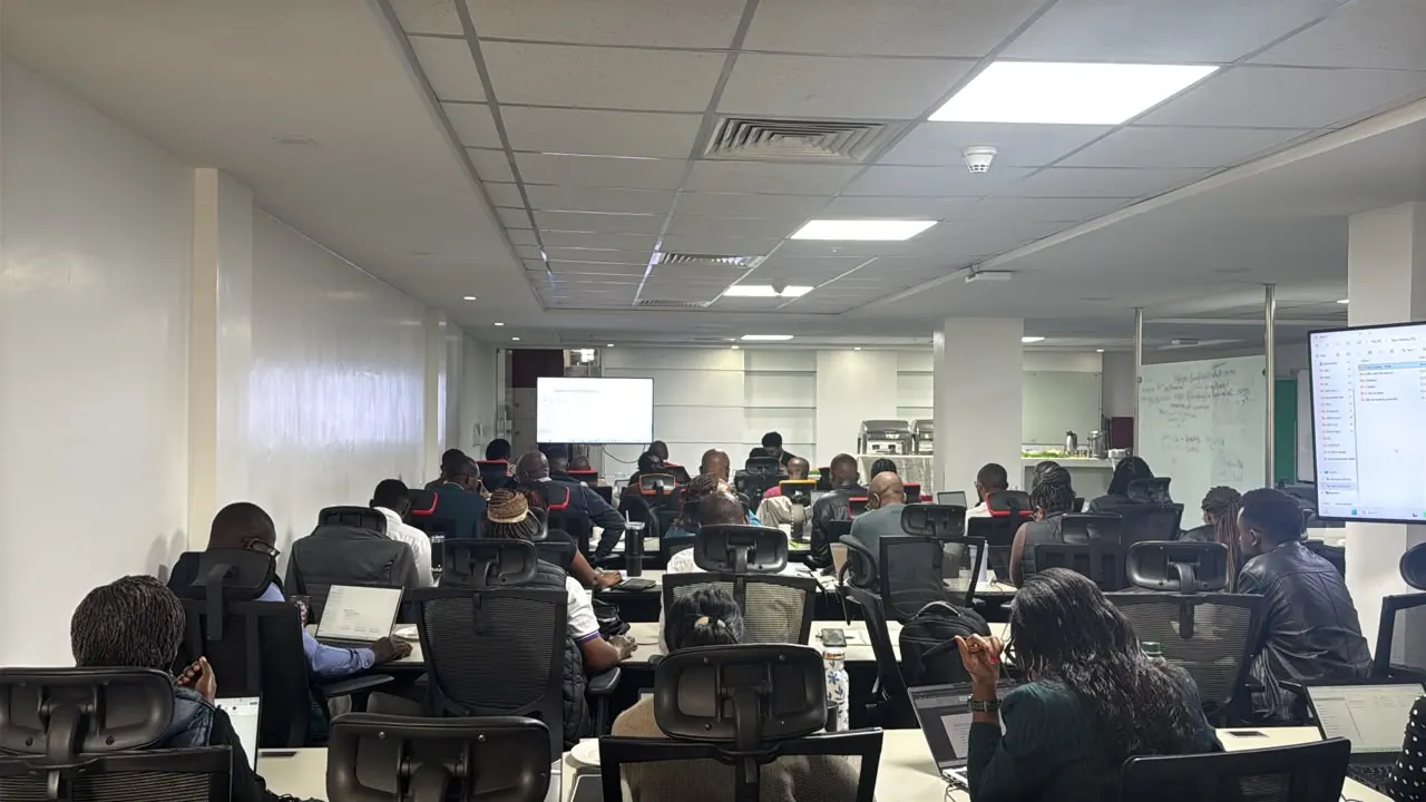 Safaricom finance professionals working on laptops during a hands-on AI lab